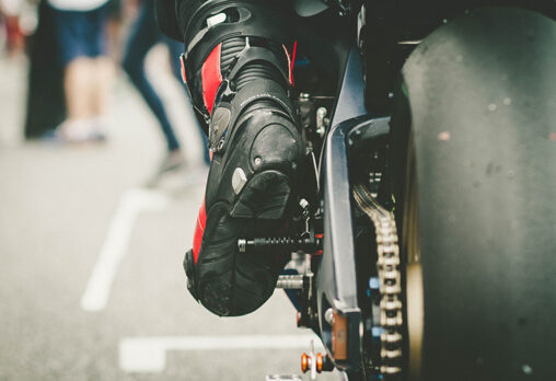 a close up of someone wearing motorcycle boots