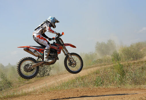 a man riding an off road motorcycle on a hill