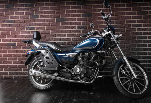 a cruiser motorcycle parked beside a brick wall