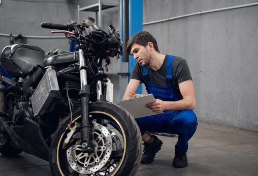 A mechanic inspecting a motorbike