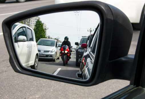 An image of a motorcycle in traffic in a sideview mirror