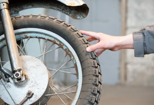 A hand touching a motorcycle tyre