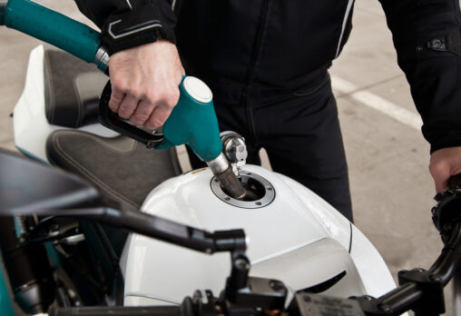 hand fuel nozzle in pouring to motorcycle at gas station
