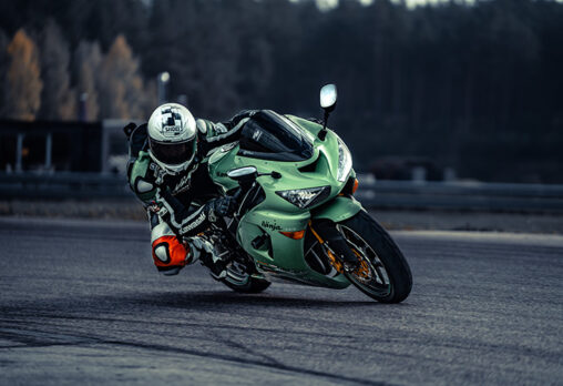 a green motorcycle turning a corner