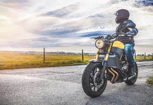 a man sitting on a street motorcycle on the road